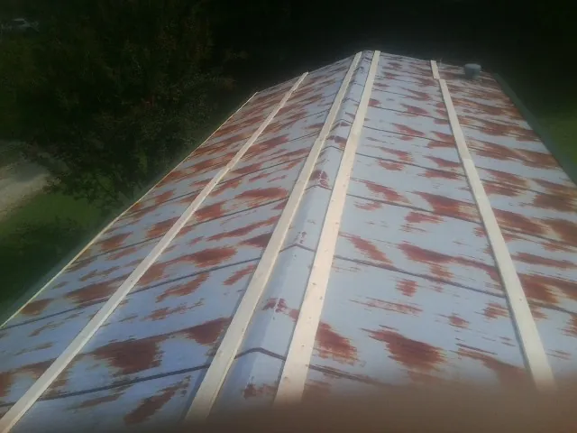 Rusted metal roof panels with new wood purlins before replacement — Storm Damage Roof Repair in Mount Gilead by Roofing Brothers