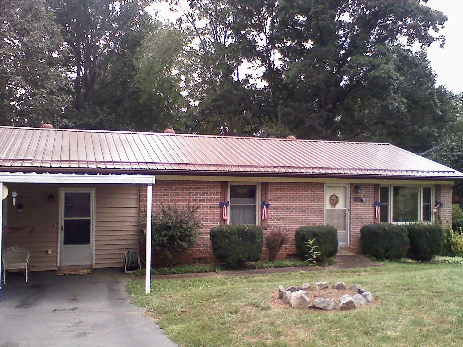 Bronze metal roof and carport on a brick ranch home — Roof Repair work by our crew in Mount Gilead